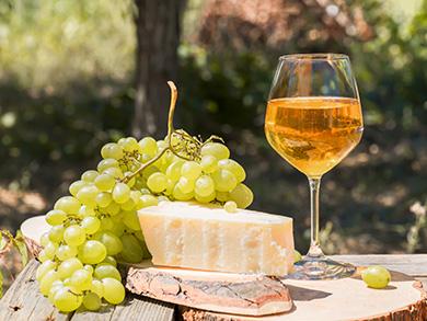 Billede er flot orangevin med ost og grønne vindruer. 